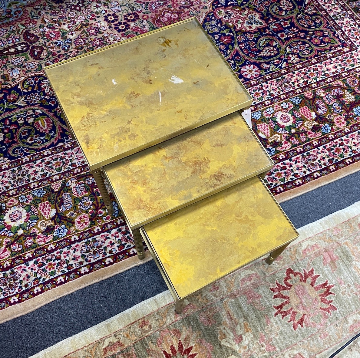A nest of three Maison Jansen style glass top brass occasional tables, width 50cm, depth 36cm, height 36cm